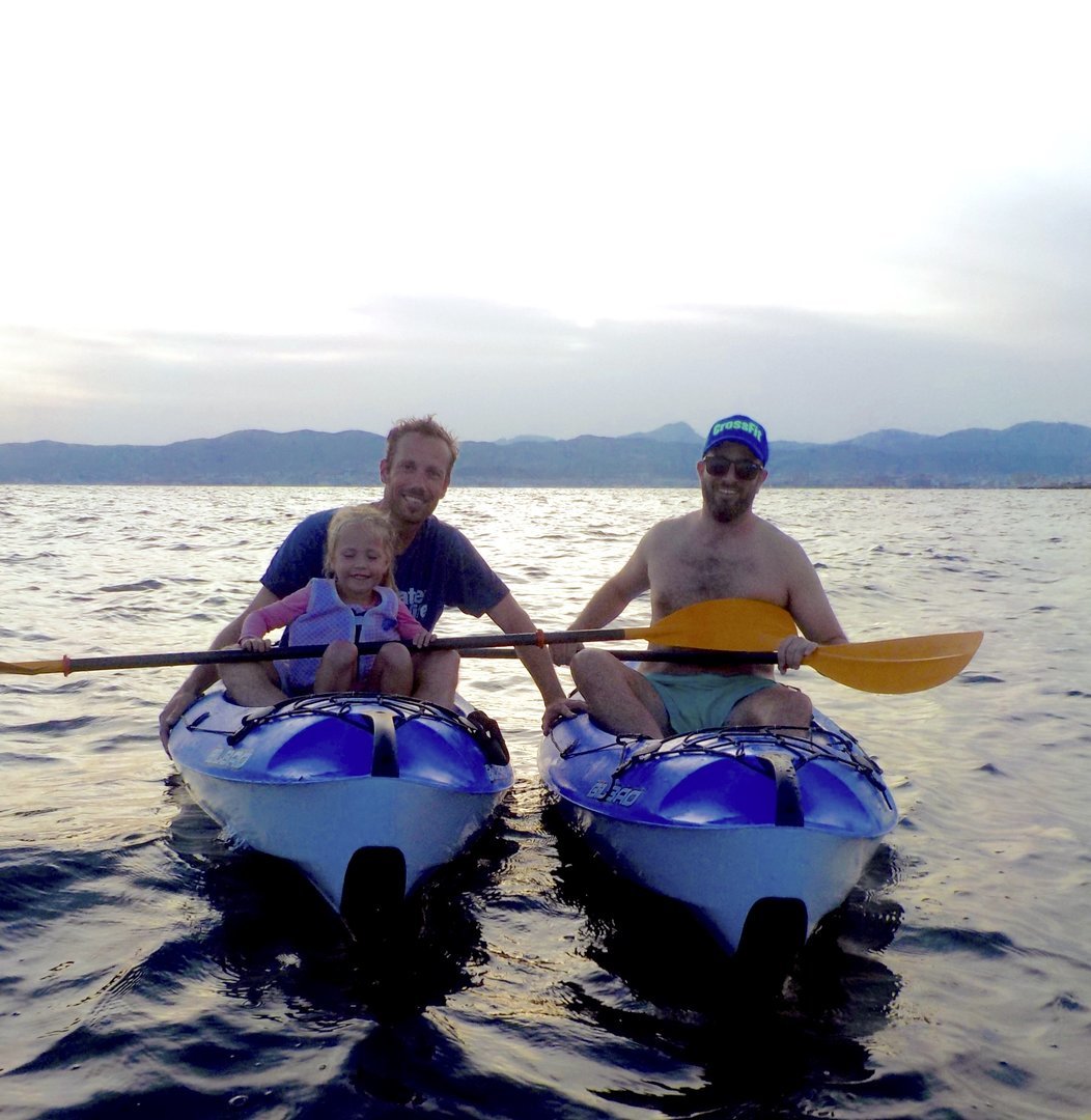 familia en kayak al atardecer